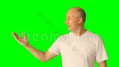 一个笑着的年轻人在绿色屏幕上做手势。用手和头做宽笑手势。带预乘的夹子